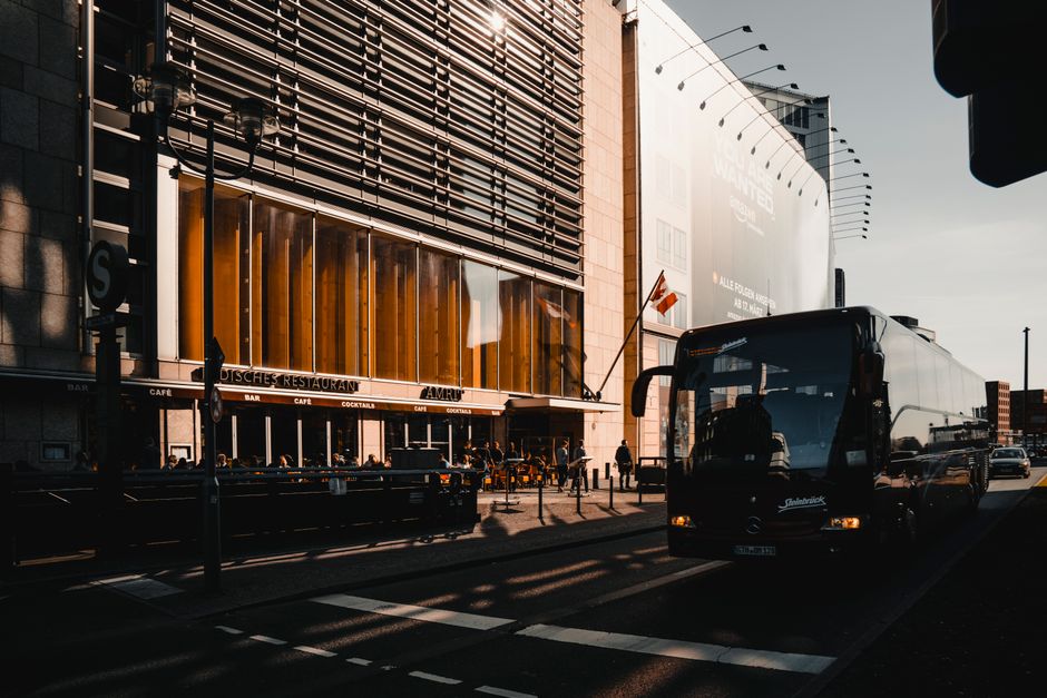Busy urban street in Berlin with a bus and modern architecture during the day.
