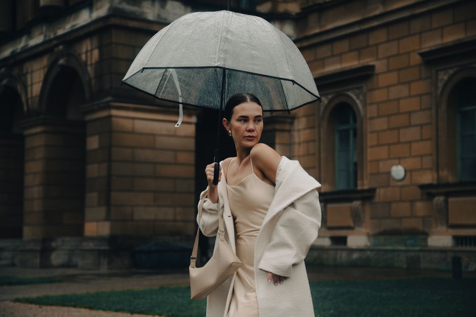 Fashionable woman with umbrella walking in rainy Munich street