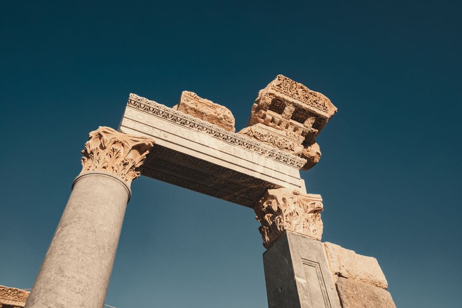 A stunning view of ancient Roman ruins with intricate carvings under a clear blue sky.