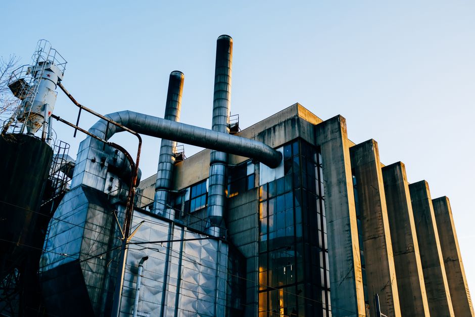 Low angle exterior of factory located on city street under blue sky in evening time