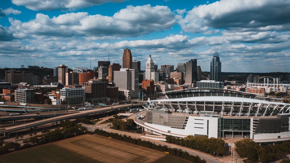 Exterior of large oval Soldier Field surrounded by junction and greenery under sky covered with clouds in Chicago