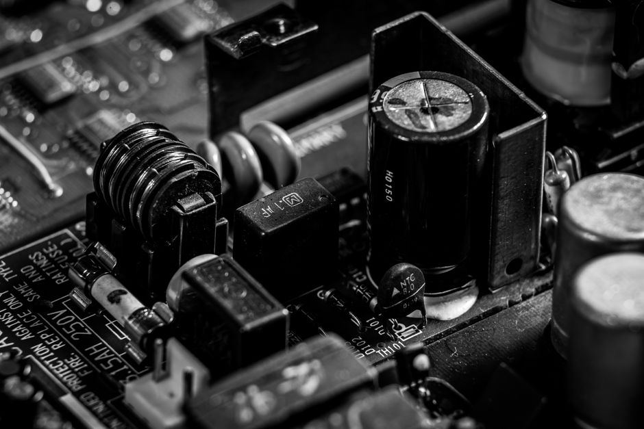 Detailed black and white image of electronic circuit board components for technology backgrounds.