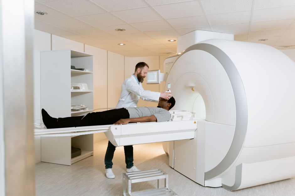 An adult patient experiencing a medical scan guided by a healthcare professional in a modern facility.