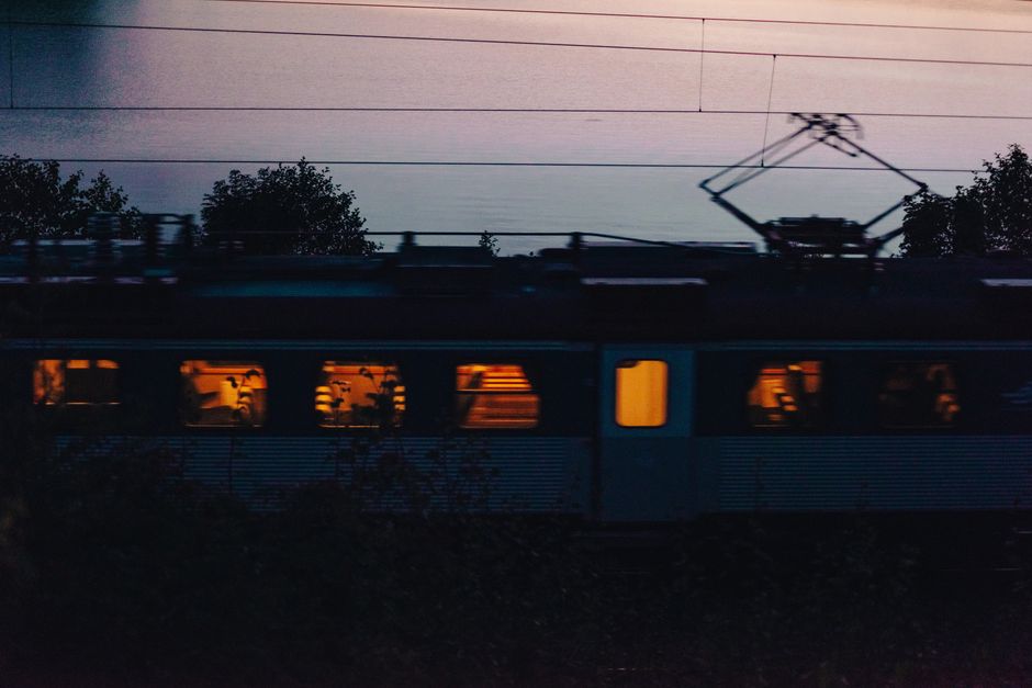 Silhouette of a moving train against a picturesque sunset sky, capturing the calm evening atmosphere.