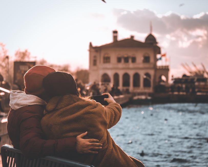 Couple enjoys a cozy moment on the waterfront in Türkiye, capturing a selfie with scenic views.