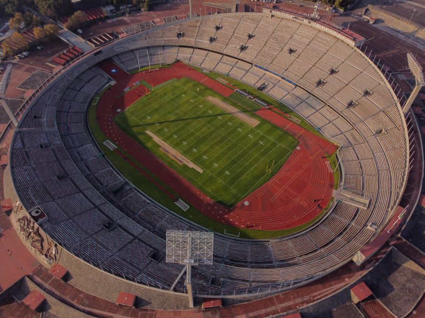 High-angle aerial view of an empty stadium with a field and track, showcasing its architectural design.