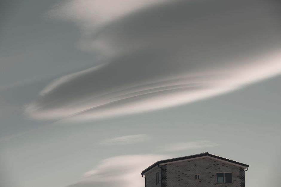 Low angle view of a modern building silhouetted against dramatic cloud formations in Goseong-gun, South Korea.