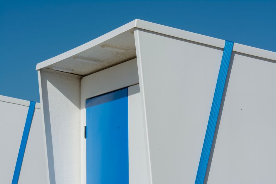 A close-up of modern architecture showcasing minimalist design with striking blue accents under a clear sky.