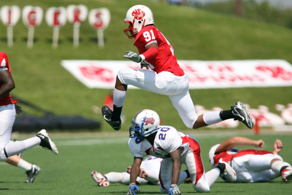 High-energy American football action with players in motion on the field during a daytime match.
