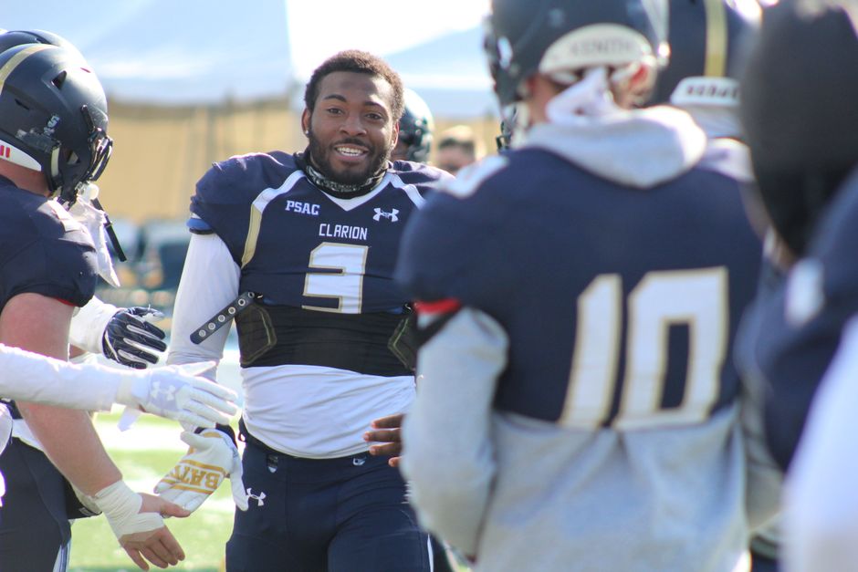 Energetic scene of college football players celebrating a play, showcasing teamwork and athleticism.