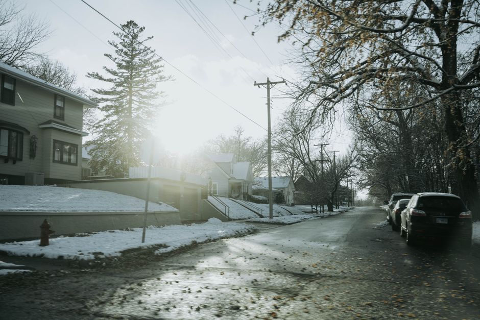 A winter street scene in Dixon, IL, showcasing frosty roads and residential houses under bright sunlight.