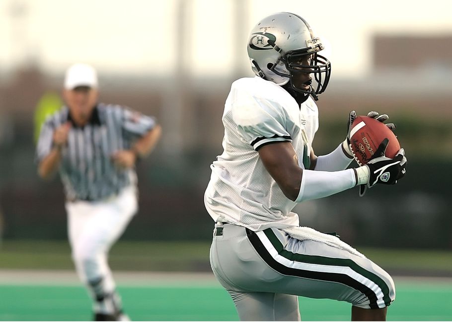 Dynamic action shot of a football player catching a pass on the field.