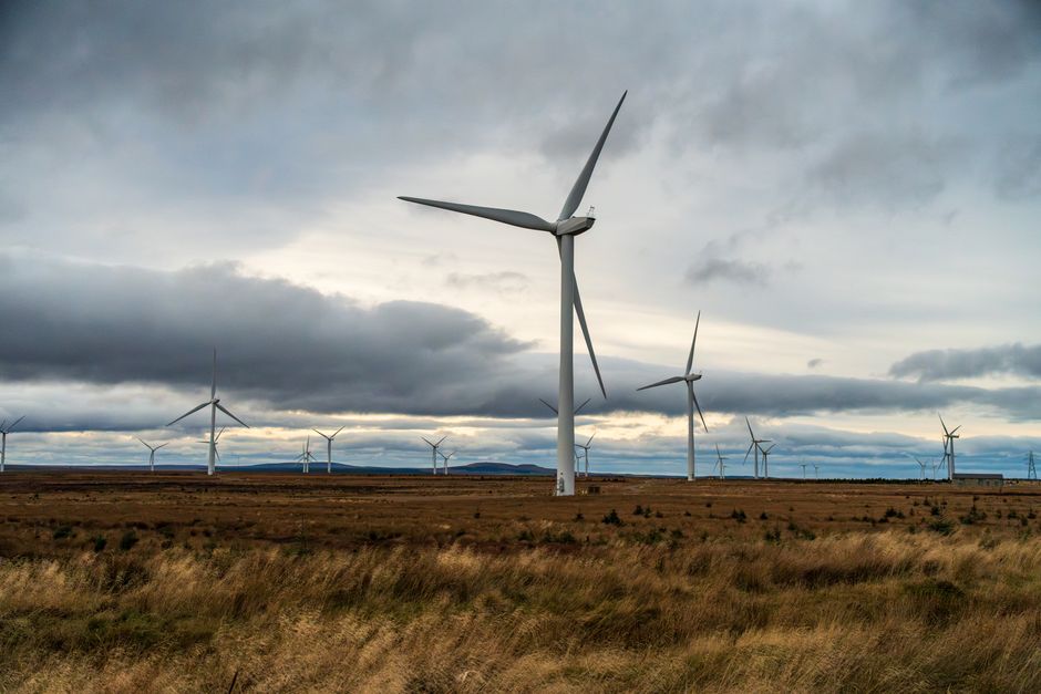 Expansive wind farm with wind turbines against a moody sky, showcasing renewable energy.