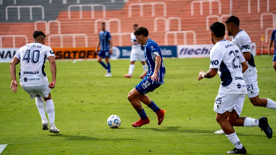 Players in action during a competitive soccer match on a sunny day.