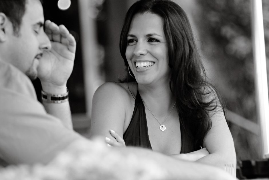 A candid black and white photo of two adults enjoying a conversation at a cafe in Miami Beach.