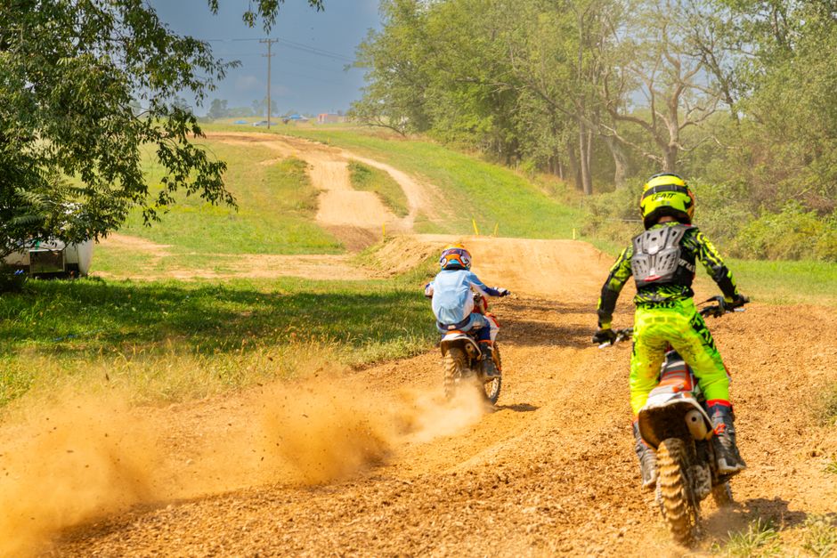 Two riders navigate a dirt track in Cecil-Bishop, Pennsylvania, showcasing thrilling bike racing action.