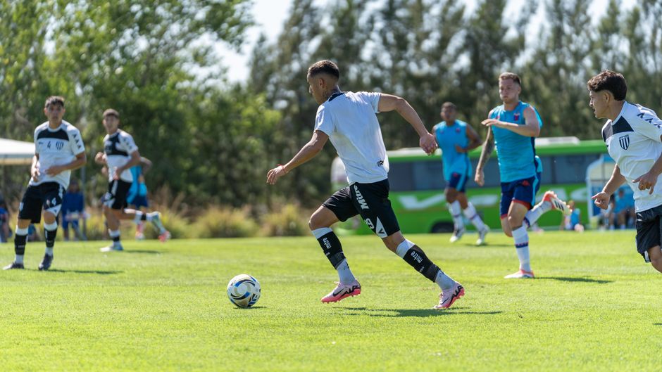 Players engaged in a competitive soccer match outdoors on a sunny day.
