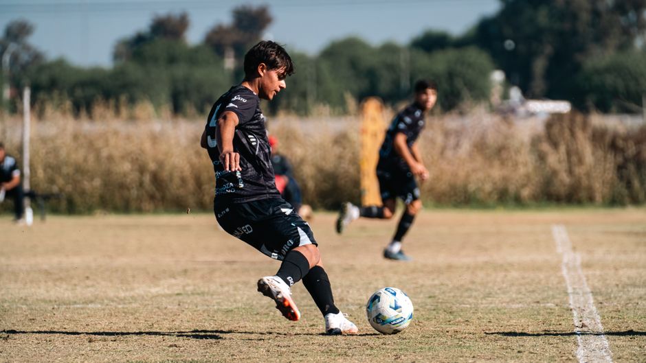 A soccer player in action during a match on a sunlit outdoor field, showcasing sportsmanship and skill.