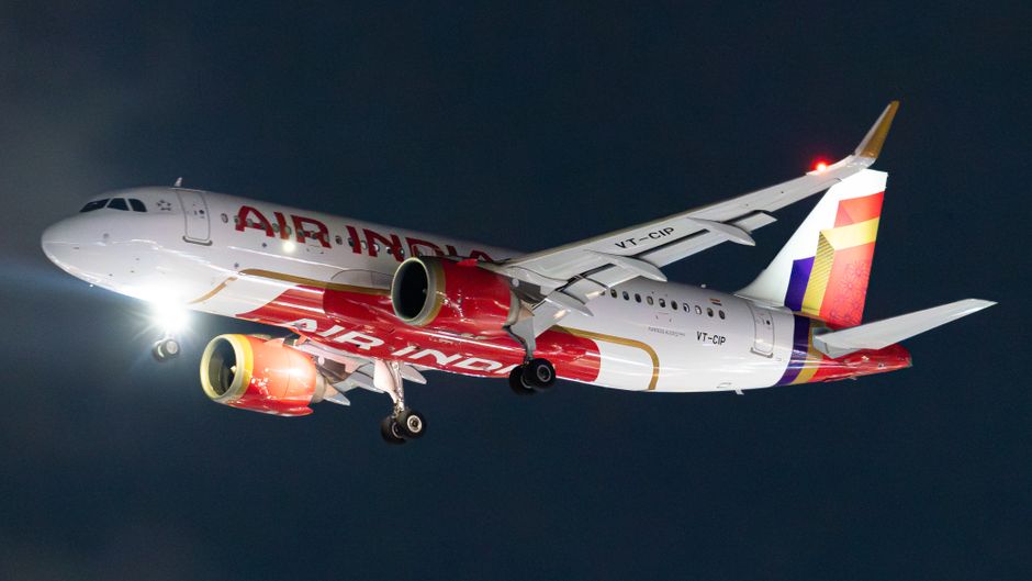 Air India Airbus A320 aircraft captured in a night landing sequence.