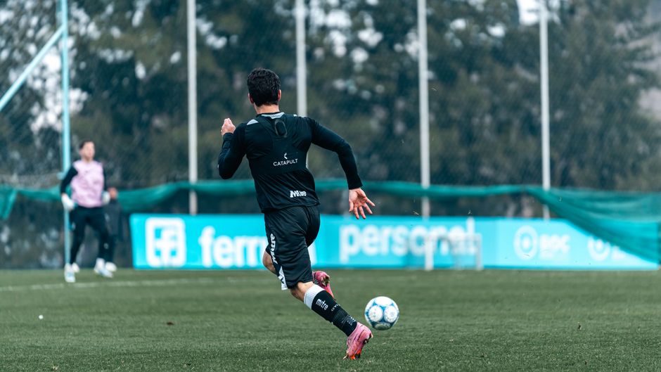 Action-packed soccer practice with players training on a green field, focusing on skills and teamwork.