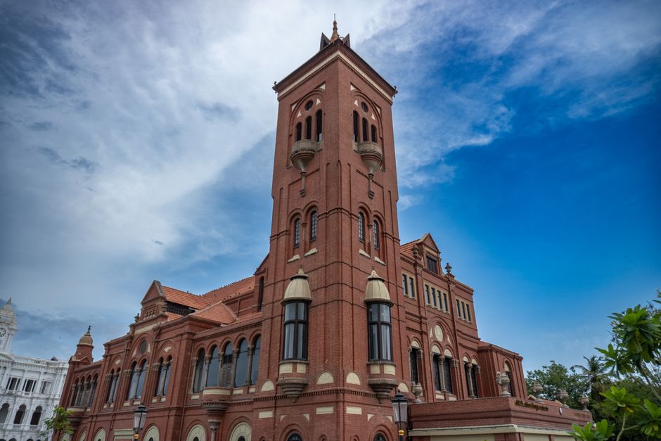 A stunning red brick building with elegant architecture and clear blue sky backdrop.