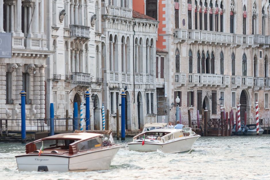 Boats gliding along a Venetian canal lined with historic architecture, emblematic of Venice's charm.
