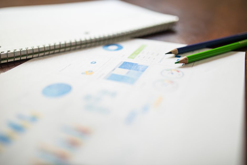 Close-up of colored pencils on an analytics report for education or business purposes.