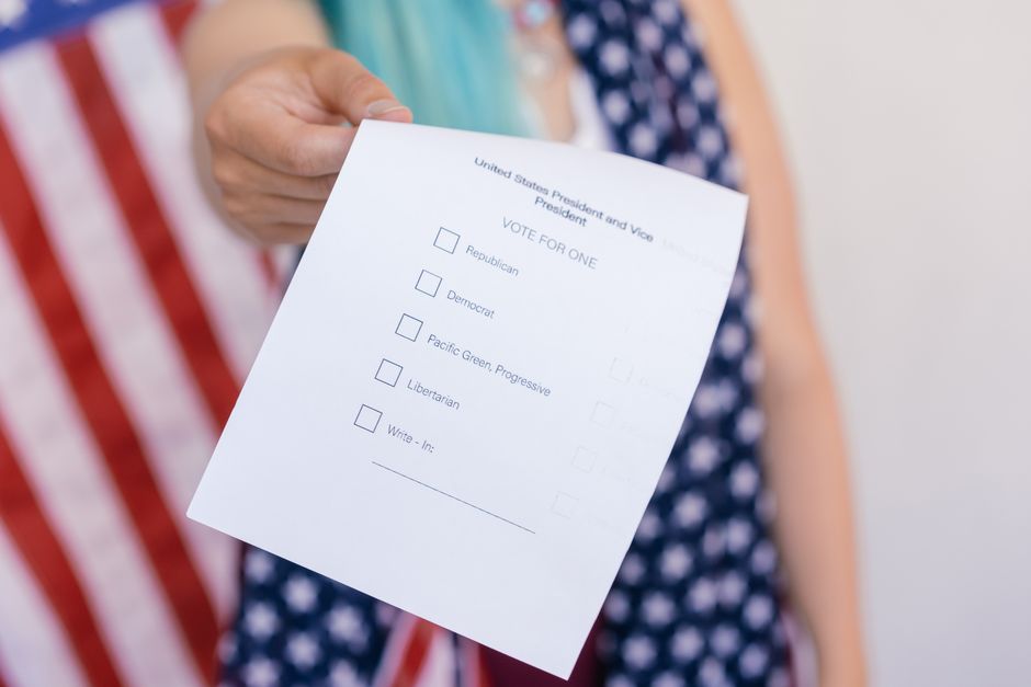 Close-up photo of a hand holding a US election voting ballot.