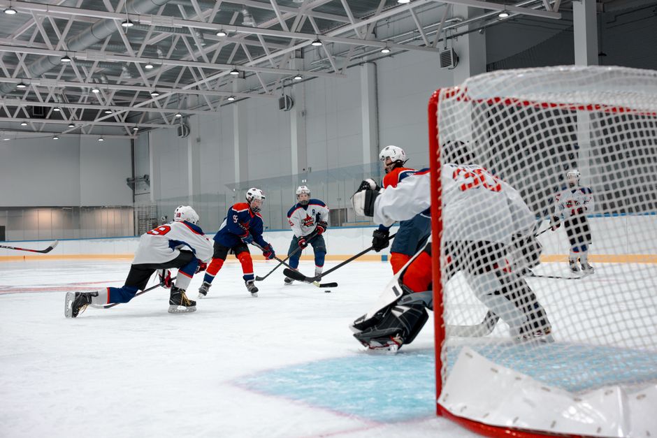 Competitive ice hockey game with players in action at an indoor rink.