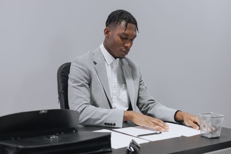 Focused businessman in gray suit reviewing documents at a desk, conveying professionalism.