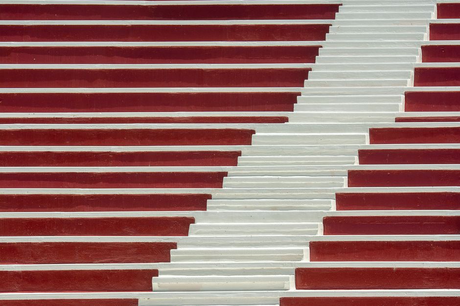 Red and white pattern of an empty stairway creates abstract visual art.